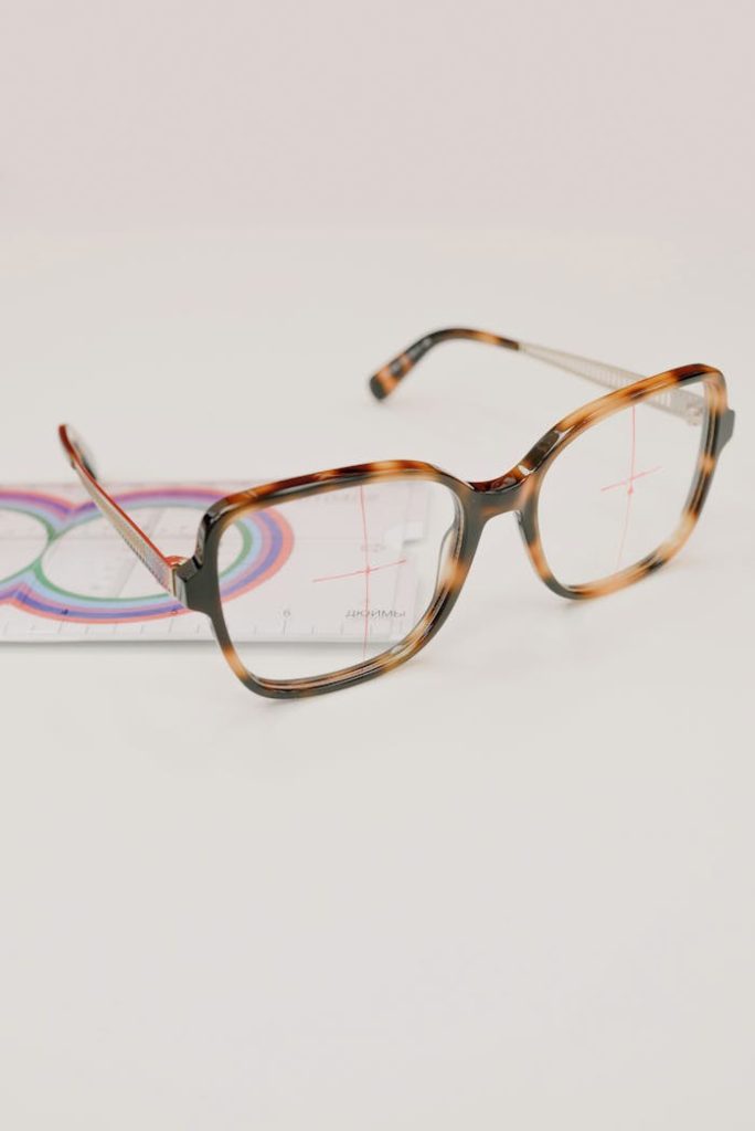pexels-photo-5752395 Stylish tortoise shell eyeglasses with a measuring ruler on white background.